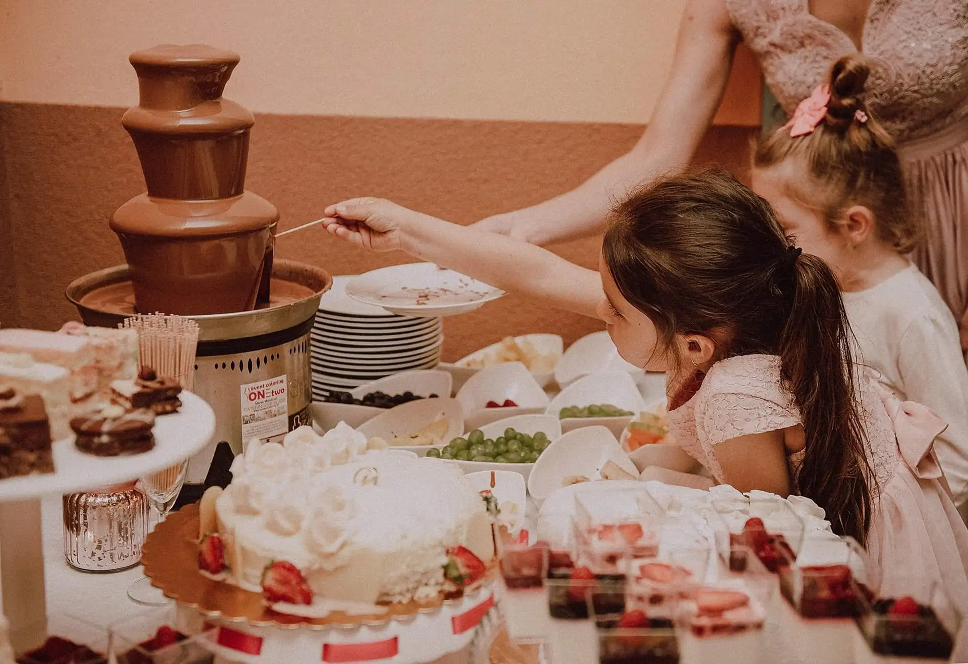 Kinder nehmen sich am süßen Buffet vom Schokobrunnen
