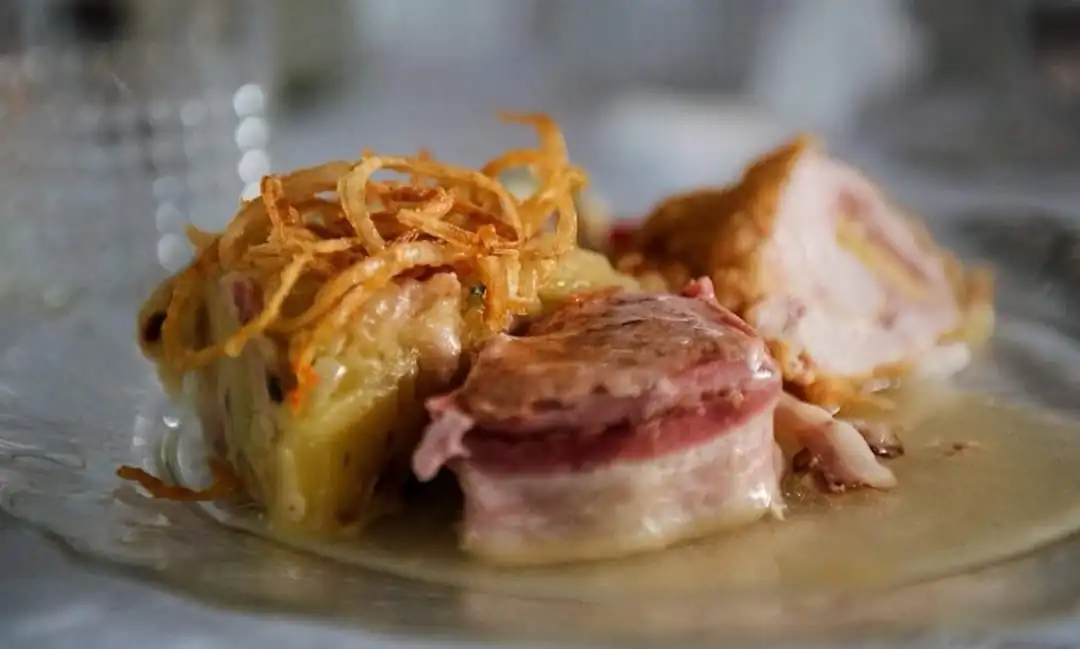 Hauptgang — gefülltes Fleisch mit Zwiebelchips auf dem Teller
