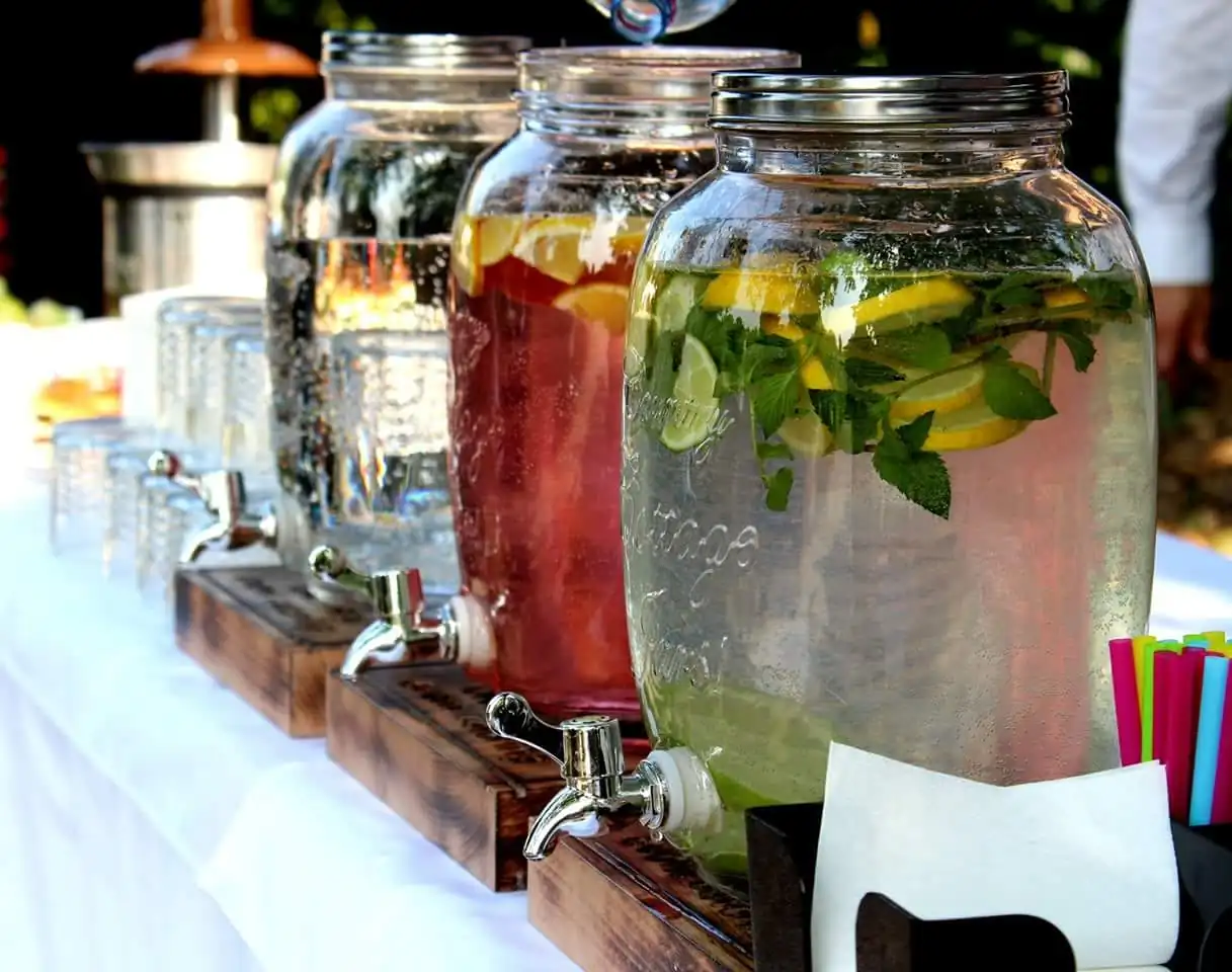 Nápojový bar so sklenenými zásobníkmi domácich limonád s citrónom a mätou